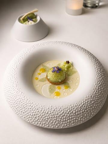 At @chateaudemirwart , @jimmyboniface skips the usual shorthand of naming dishes after their main ingredient. Instead, each course is introduced through the idea behind it: L’Élan, Âme d’Été, Jour Doré, Entre Champs et Forêt. These are less descriptions than entry points into the chef’s thinking, with the ingredients arriving only as a second layer. The effect reorients attention — away from what’s on the plate and toward why the dish exists at all.

That approach holds across the menu. Âme d’Été, built around the now-signature red mullet, evokes a Mediterranean fish spending the season in the Ardennes, set among fennel, beef tomatoes and wild herbs. Jour Doré pairs Japanese A4 Wagyu with corn and blueberries. Entre Champs et Forêt brings duck from the nearby Ferme de Flomont together with girolles, ginger and the local liqueur Le Chasseur. Each dish reads as tied to a place, a memory or a season, rather than assembled simply from its components.

The desserts follow the same logic. Essences works elderflower, cultured milk and timut pepper with notable restraint. Anthèse, named for the flower it depicts on the plate, combines cucumber, yoghurt, calamansi and juniper for a finish that’s fresh and slightly unexpected.

It’s a menu built to be read as much as eaten. By naming each course for its inspiration rather than its contents, Jimmy gives every plate a stated intention before it arrives at the table — turning the meal into a sequence of chapters, each revealing another side of a chef whose imagination is becoming as distinctive as his technique.

#GaultMillau #Gastronomie #mastercooksofbelgium #VisitWallonia #Ardennes