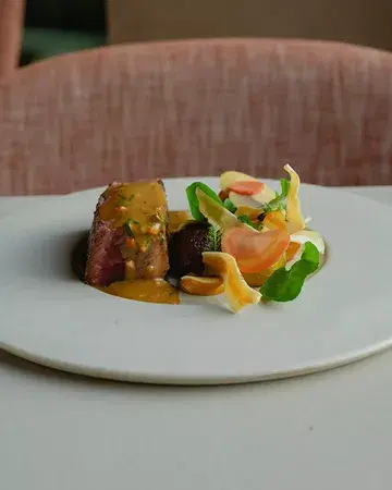 Mature grass-fed Holstein beef from Ferme de l’Esclaye in Beauraing, lifted by a fresh chimichurri emulsion and a colorful trio of gnocchi: sweet potato, red cabbage, and dill.