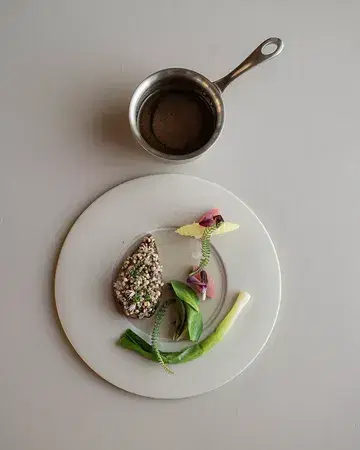Enjoy the squab from Pigeonneau des Collines by Jérôme Demeyer, glazed with gochugaru miso. A deeply reduced pigeon jus infused with blackcurrant buds and preserved truffle, finished with puffed buckwheat crumble and seasonal vegetables ✨