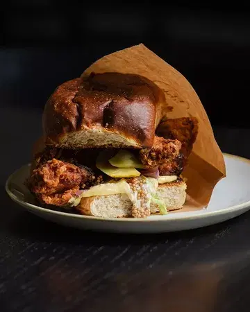 CHICKEN CUBANO - Shoyu koji & buttermilk fried chicken thigh, kombucha BBQ sauce, pickles, mustard mayo on a homemade Hawaiian sweet bun.
 
One bite and you get it. At FRANK! 🖤