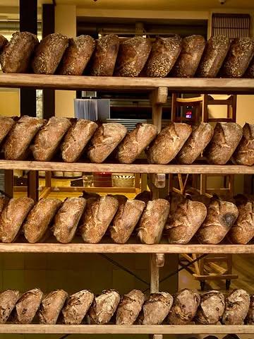 Beste klanten,

We merken dat er soms vragen zijn over onze openingstijden in het weekend. Daarom willen we graag uitleggen waarom we bewust kiezen om pas om 8u30 te openen op zaterdag en zondag.
In het weekend starten we om 5 uur ’s morgens, zodat alles vers en op tijd klaarstaat voor opening. Vroeger openen zou betekenen dat we ook vroeger aan de werkdag moeten beginnen. Voor ons is het belangrijk dat ook bakkers een sociaal en gezinsleven kunnen hebben — iets wat in onze sector vaak moeilijk combineerbaar is en mee verklaart waarom zoveel mensen het beroep op een bepaalde leeftijd verlaten. Door om 8u30 te openen, proberen we een wankel evenwicht te bewaren tussen werk en privé.

Daarnaast zijn de uren vóór opening voor ons net de drukste momenten van de dag. Dan wordt alles afgewerkt en klaargezet, en krijgt het winkelteam nog een briefing over het assortiment, nieuwe producten en praktische zaken van die dag. Net zoals in de meeste andere winkels is het daarom niet haalbaar om klanten te bedienen vóór openingstijd.

We doen ons werk elke dag met veel liefde en passie, en proberen dat iedereen met een goed gevoel de winkel verlaat.
We hopen op jullie begrip, en hopelijk tot binnenkort! ❤️