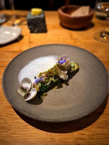 Du champ à l’assiette : Concombre rôti, cornichon maison & coquillages 🥒🦪

L’assiette s’articule autour d’un jeune concombre provenant des Jardins de @biok.be à Corbais. 
Cette variété naine permet d’obtenir de petits concombres particulièrement généreux en goût. Certains sont simplement rôtis afin de développer leur douceur naturelle tout en conservant leur fraîcheur végétale.

Le cornichon de notre potager (merci @terres_gourmandes_potagers ), proche cousin du concombre, est ici travaillé en pickles.

Dans cette entrée marine, différents coquillages sont travaillés selon les pêches et les arrivages du jour : huîtres, palourdes, praires, couteaux ou encore coques. 

Les coquillages proviennent directement de la criée d’Erquy et sont sélectionnés avec soin par notre mareyeur Walter Dubois qui nous livre en direct de Bretagne 1 fois par semaine.

Le jus de cuisson des coquillages est soigneusement récupéré puis travaillé en sauce afin d’obtenir un jus savoureux, concentré et profondément iodé.