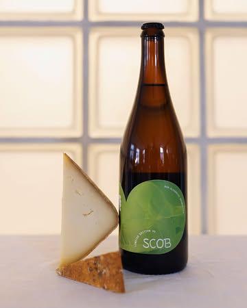 Accords @scob.brewery & Fromage

Jassid & Ossau-Iraty

Ici, une cuvée tranquille (non pétillante) aux notes vineuses portées par l’acidité des zestes d’agrumes.  Produite à partir d'un thé noir Darjeeling (Jardin Rohini, Inde – IGP). Cette édition est élaborée à partir d'un thé de printemps (first flush) issu de la première cueillette de 2025, c’est une édition limitée de la brasserie.
Faire se rencontrer l’Inde et les Pyrénées, en passant par Bruxelles, c’est associer le côté vineux de Jassid à la douceur d’un lait de brebis. Produit durant la saison d’estive, cette tomme fondante et légèrement sucrée devient la compagne idéale de l’acidité fruitée de la boisson et prépare ainsi vos papilles à honorer les desserts à venir.

📷 : @maurine.toussaint